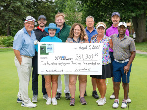 Une photo prise lors de la 21e édition du Tournoi de golf Ken Reed montrant des participants tenant un chèque symbolique représentant le montant collecté durant l'événement.