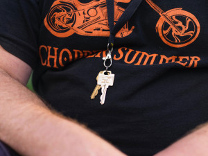 Photo of a man with a key ring around his neck.